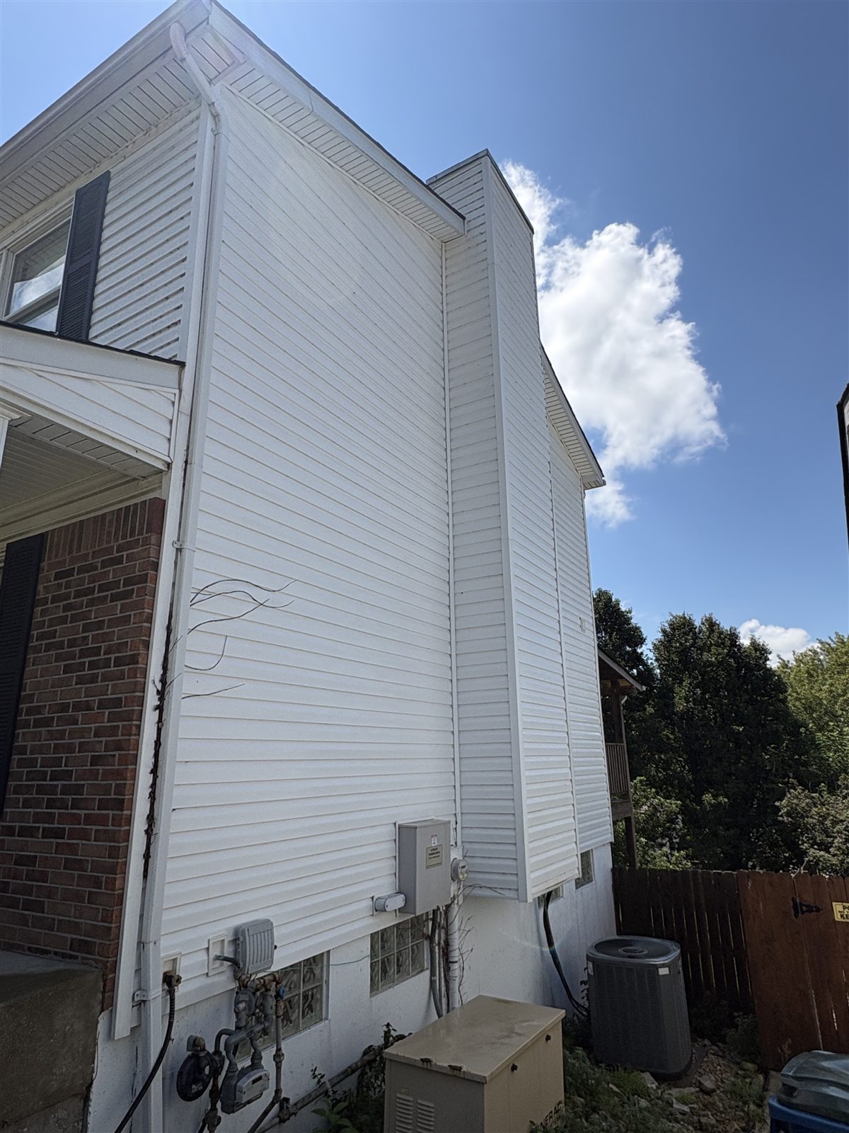 Two-story vinyl siding after soft washing, with a clean white finish, South County St. Louis